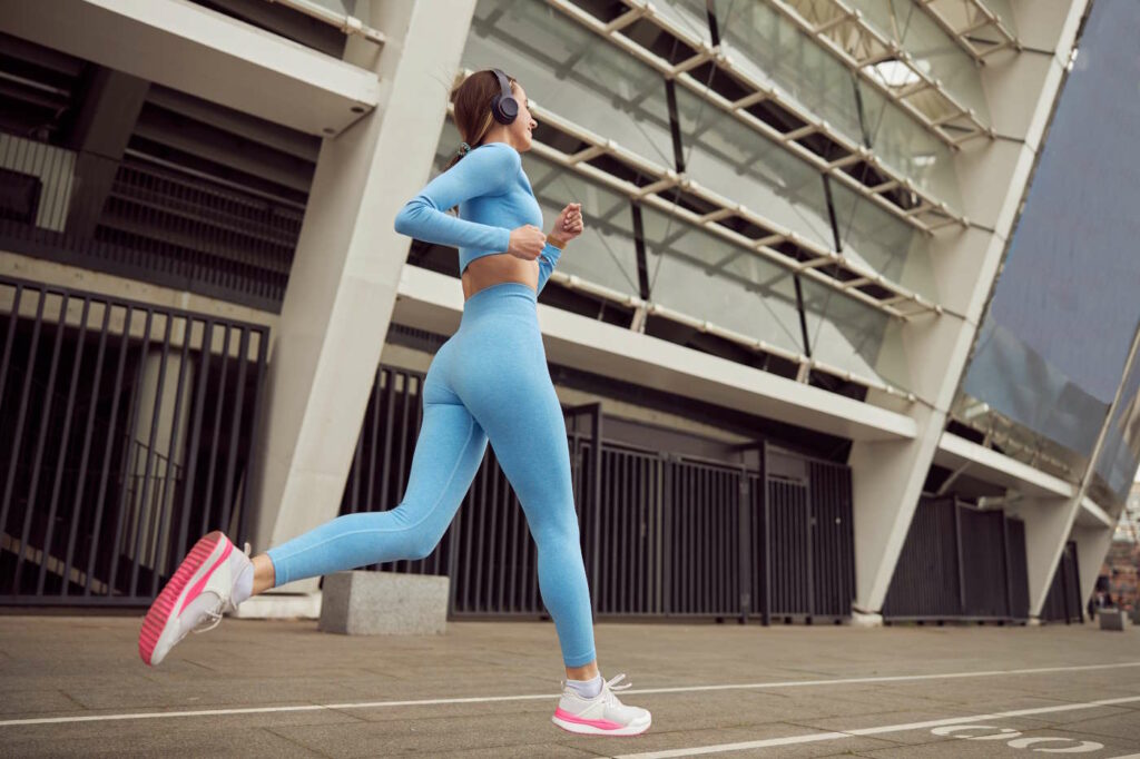 Young fit lady is doing fitness and jogging at urban place