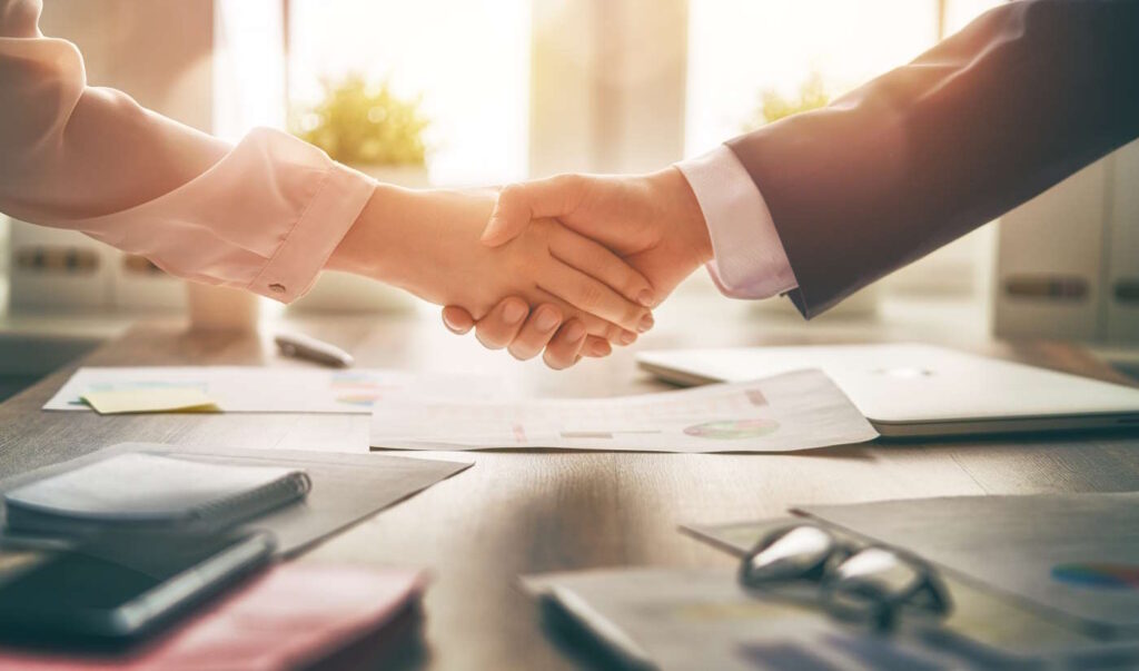 Man and woman are shaking hands in office. Collaborative teamwork.